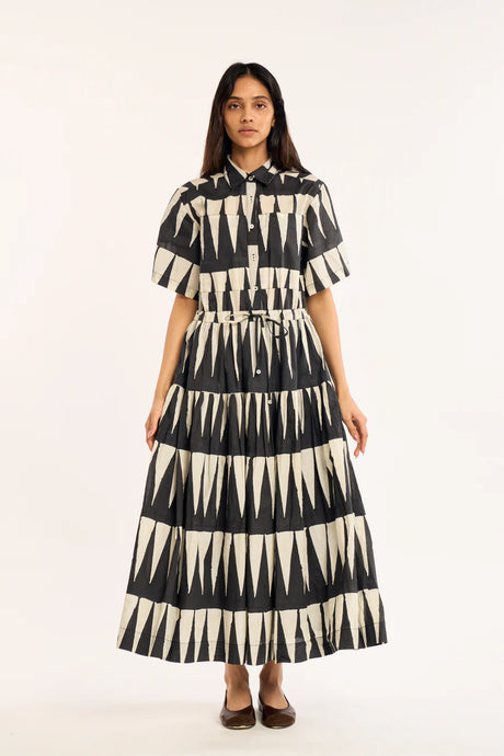 Woman wearing a black and white patterned dress on a white background