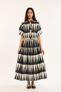 Woman wearing a black and white patterned dress on a white background
